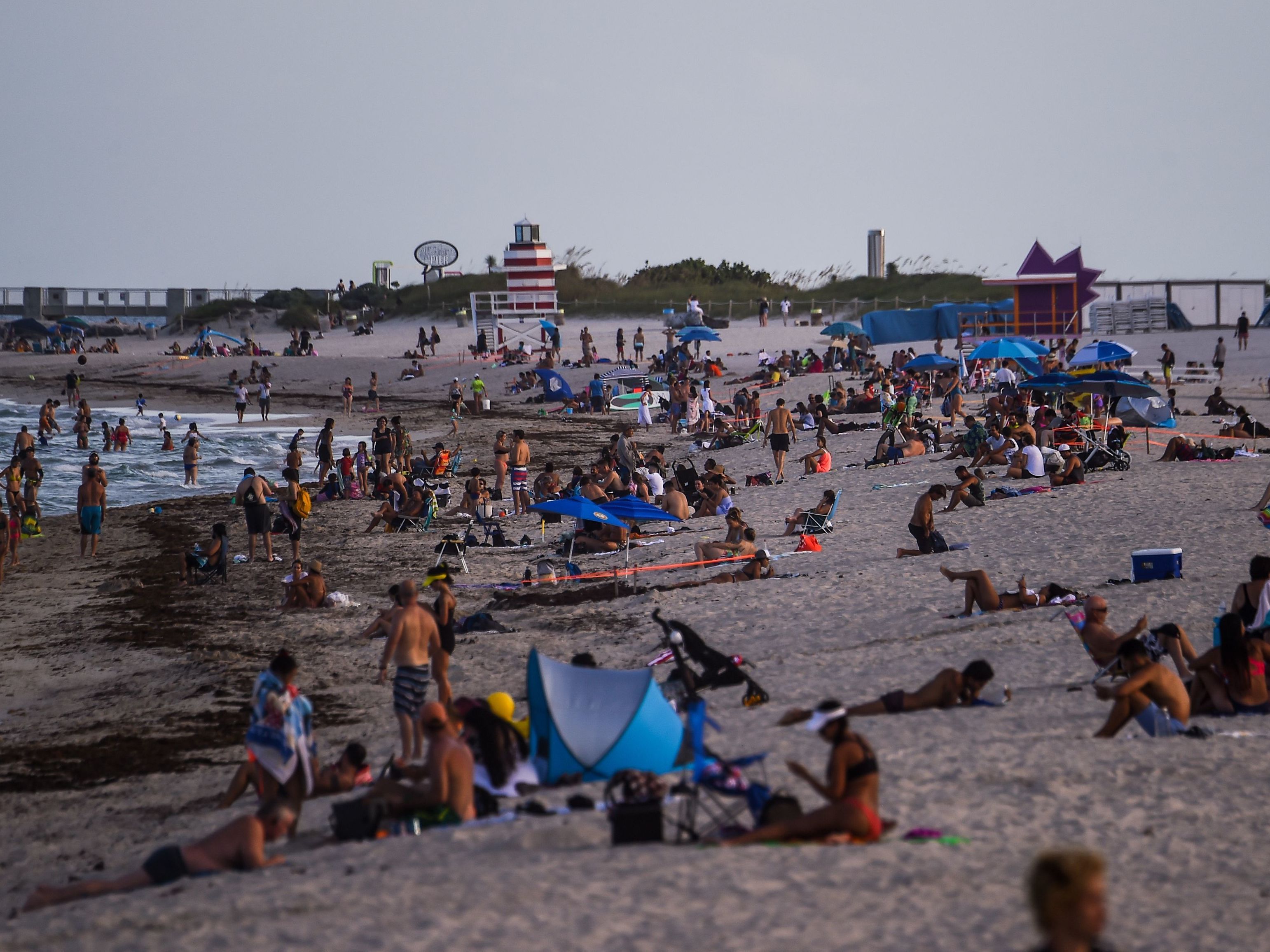 caption: People relax on the beach in Miami Beach on Tuesday.
