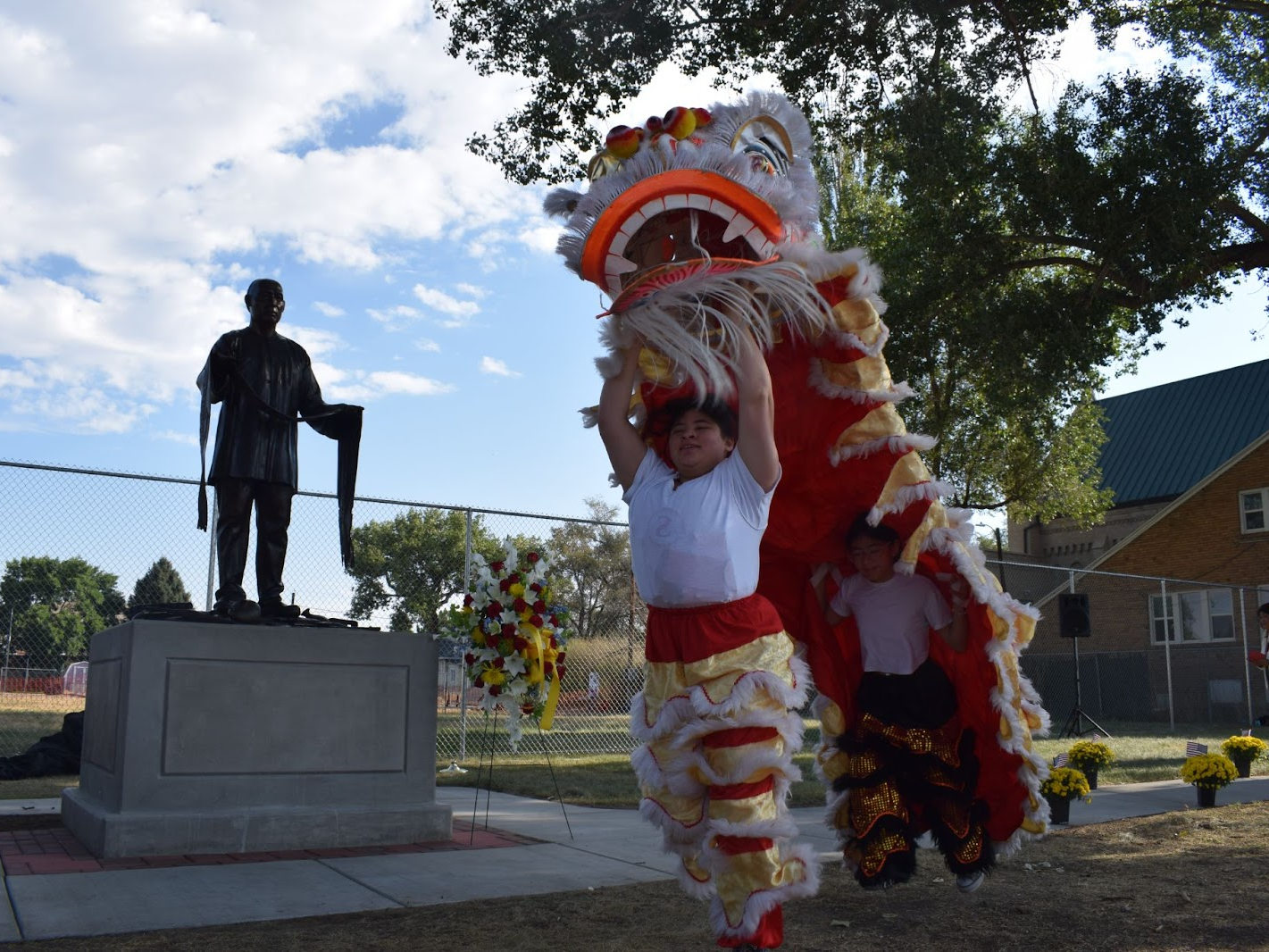 caption: Lion Dancers perform in front of a new statue of a Chinese coal miner in Rock Springs, Wyoming called "Requiem"