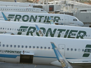 caption: Frontier Airlines jetliners sit at gates on the A concourse at Denver International Airport. Lawsuits filed on Tuesday allege that the airline of discriminating against pregnant and nursing women.