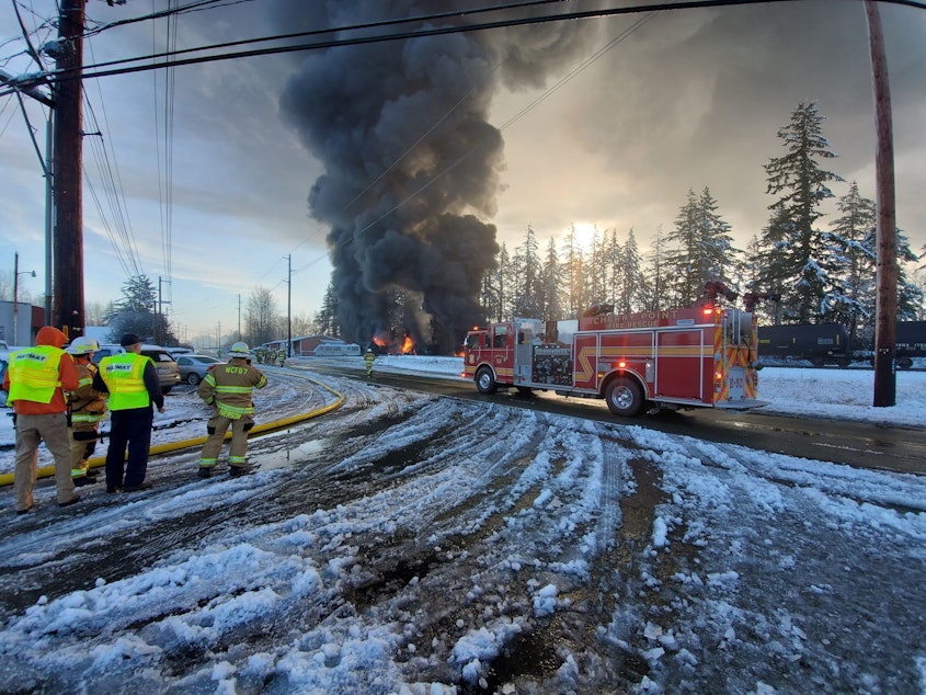 caption: Firefighters watch an oil train burn in Custer, Washington, on Dec. 22, 2020.