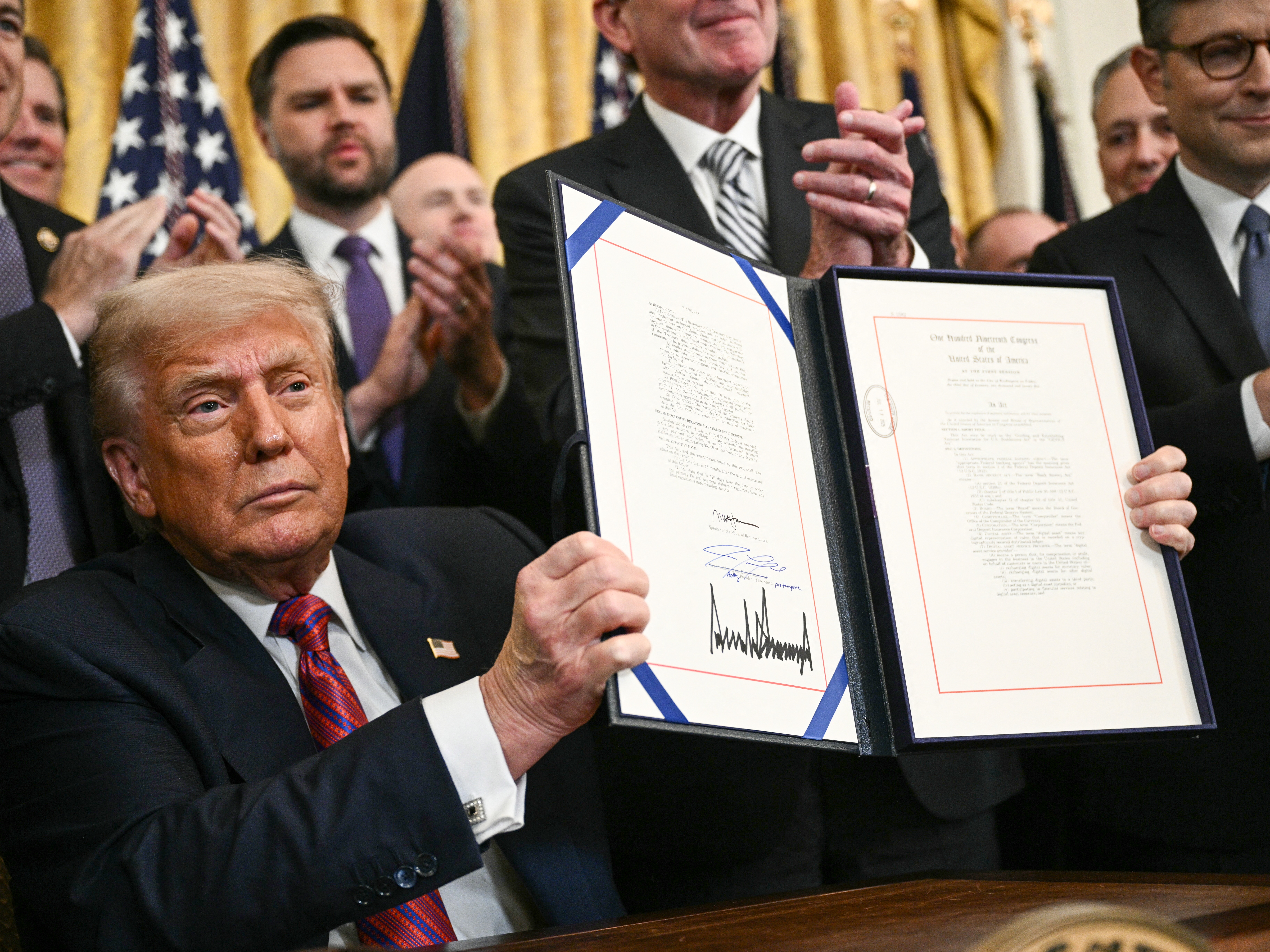 caption: President Donald Trump in July signed the GENIUS Act, the country's first major standalone cryptocurrency legislation. Trump has embraced the crypto industry, where his family now has several business ventures.