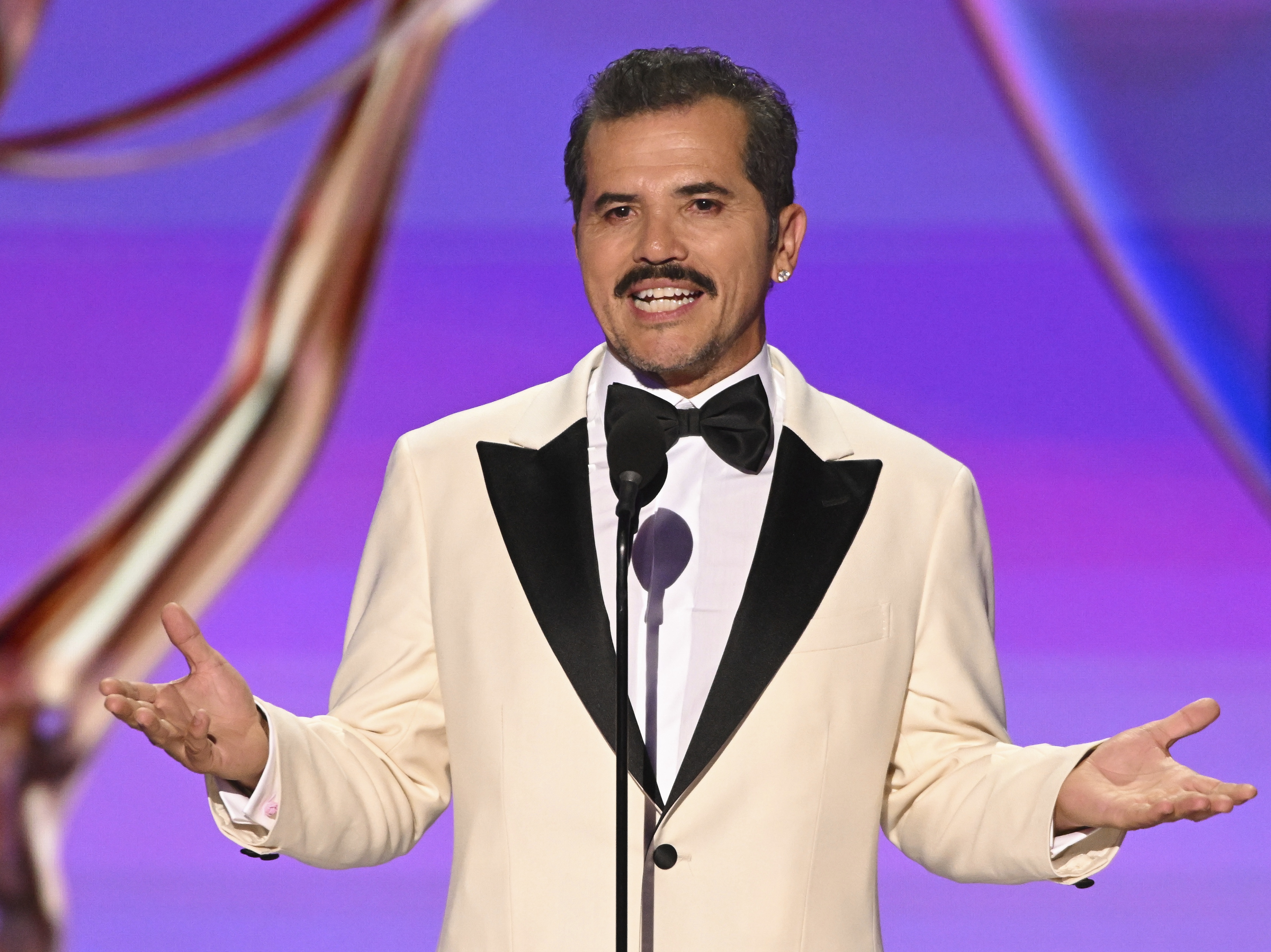 caption: John Leguizamo speaks onstage at the 76th Emmy Awards on Sunday, Sept. 15, in Los Angeles.