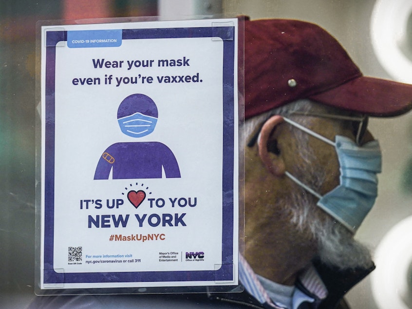 caption: A sign reminds customers that masks are required in their store in New York in December. A growing number of states are lifting their indoor mask mandates in the coming weeks.