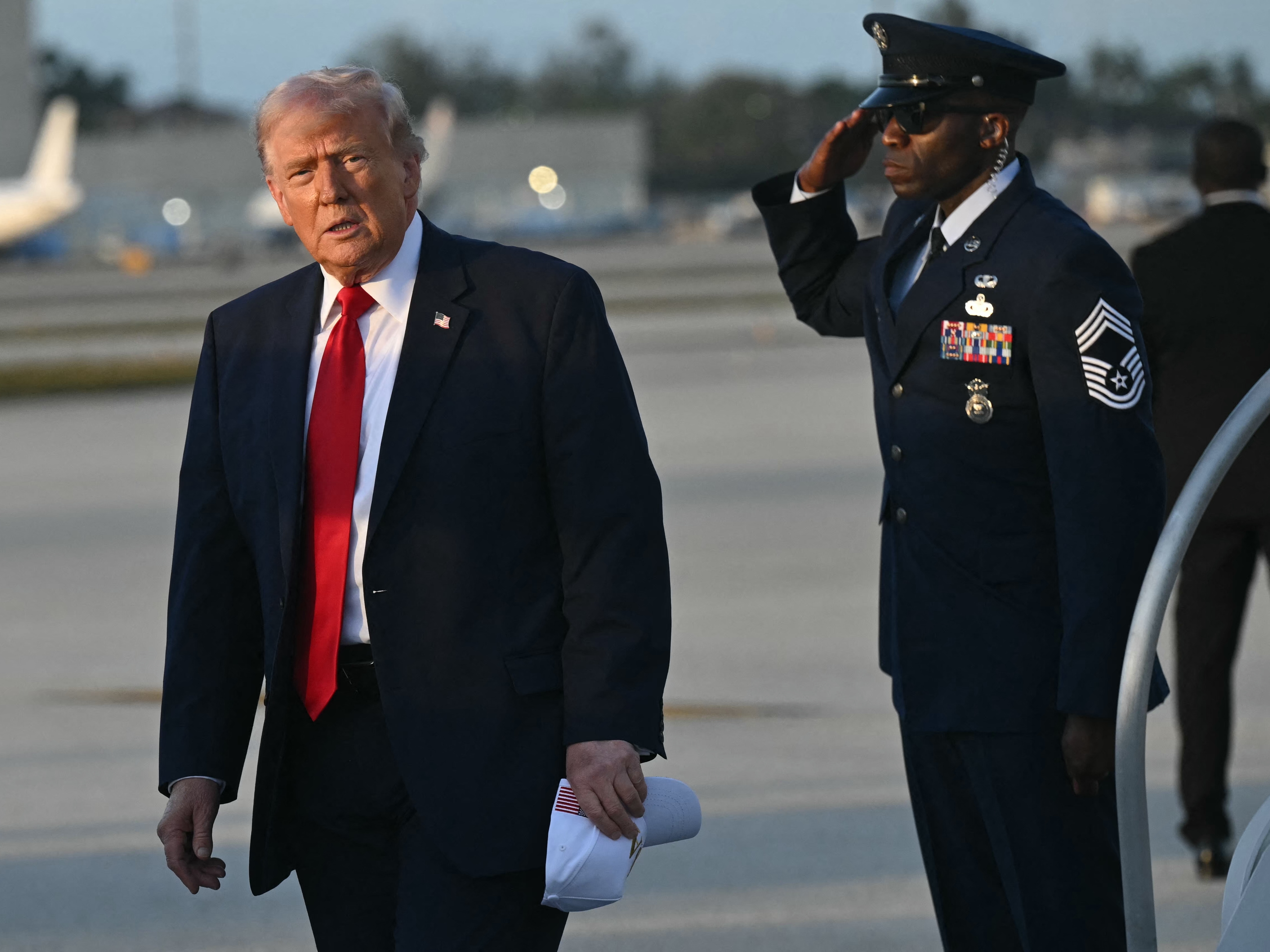 caption: President Trump disembarks from Air Force One upon arrival at Miami International Airport in Miami on March 7.