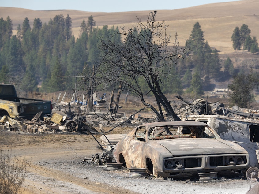 caption: Vehicles were destroyed by a wildfire in Malden, Wash., on Tuesday. Large parts of the West Coast are under warnings for elevated fire weather threats Thursday, but there may soon be a measure of relief if fire-driving winds decrease as expected.