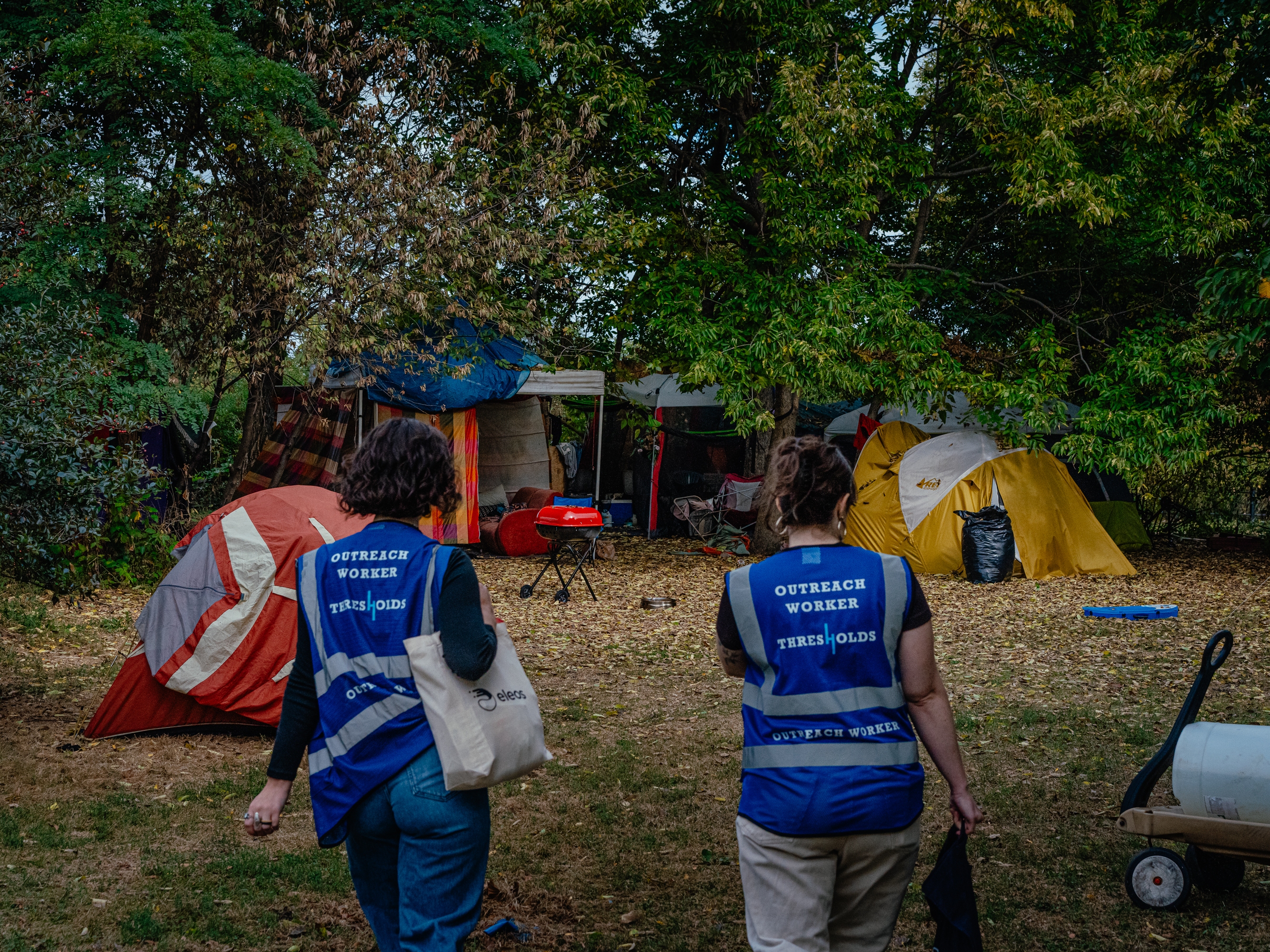 caption: The burst of new laws follows a landmark U.S. Supreme Court ruling, and reflects public frustration with record-high homelessness. Outreach workers Lillian Risser (left) and Sophia Loveland (right) approach a tent encampment in Chicago, Ill. on Sept. 23, 2024. The organization is working to rehome people living in encampments to more permanent housing.