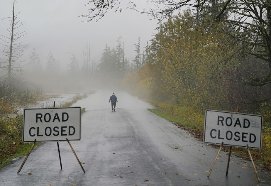 caption: Clyde Shew, of Snoqualmie, Wash., checks out a section of W. Snoqualmie River Rd. NE that was closed due to high water conditions from the Snoqualmie River, Friday, Nov. 12, 2021, near Carnation, Wash. Flood watches and warnings were in place across the Northwest and forecasters said storms caused by an atmospheric river, known as the Pineapple Express and rain were expected to remain heavy in Oregon and Washington through Friday night.
