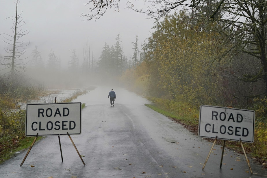 caption: Clyde Shew, of Snoqualmie, Wash., checks out a section of W. Snoqualmie River Rd. NE that was closed due to high water conditions from the Snoqualmie River, Friday, Nov. 12, 2021, near Carnation, Wash. Flood watches and warnings were in place across the Northwest and forecasters said storms caused by an atmospheric river, known as the Pineapple Express and rain were expected to remain heavy in Oregon and Washington through Friday night.