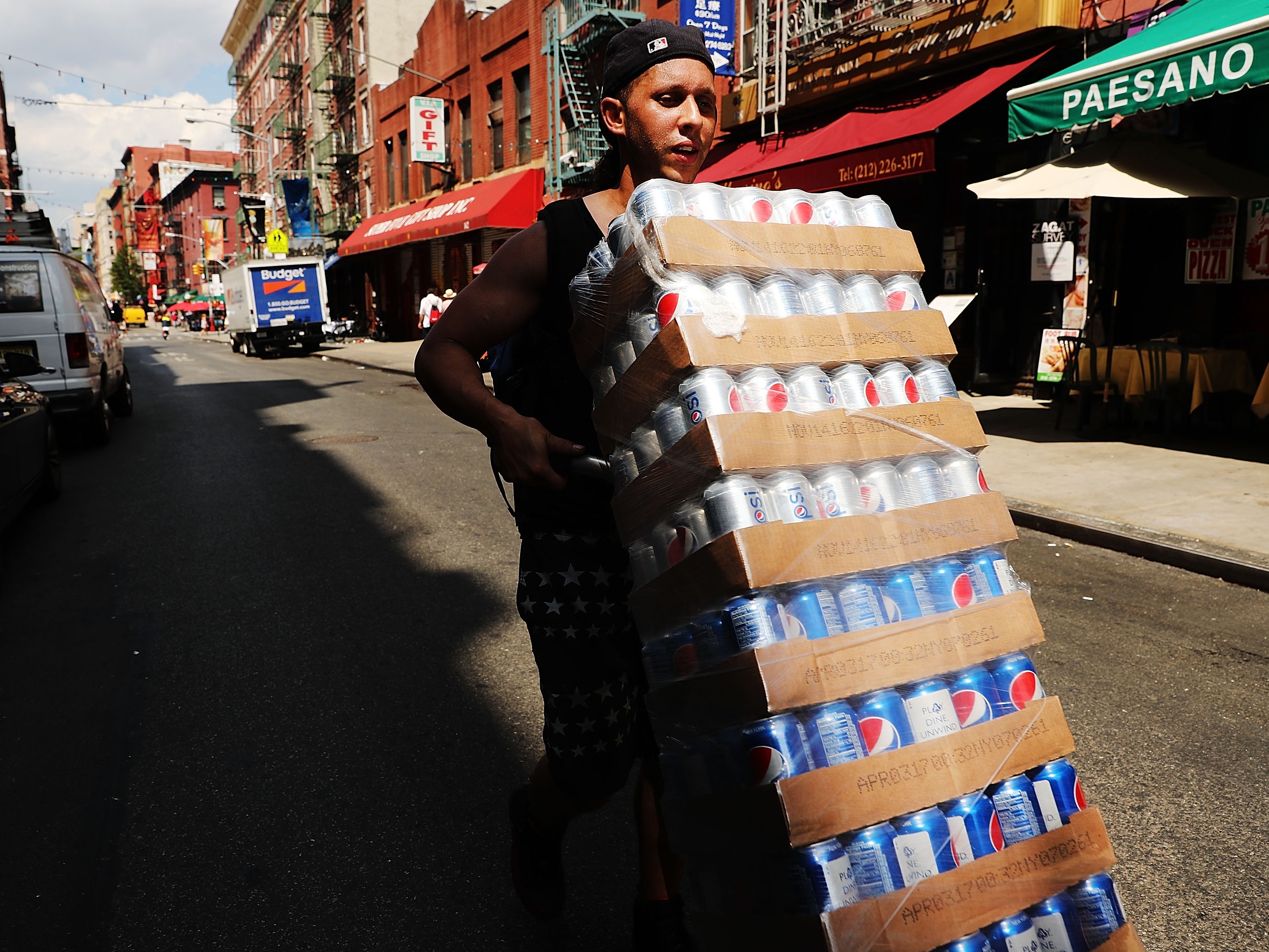 caption: Demand for sugary beverages goes up when it's hot out. Here, delivering soda on a hot July day in New York City in 2016.