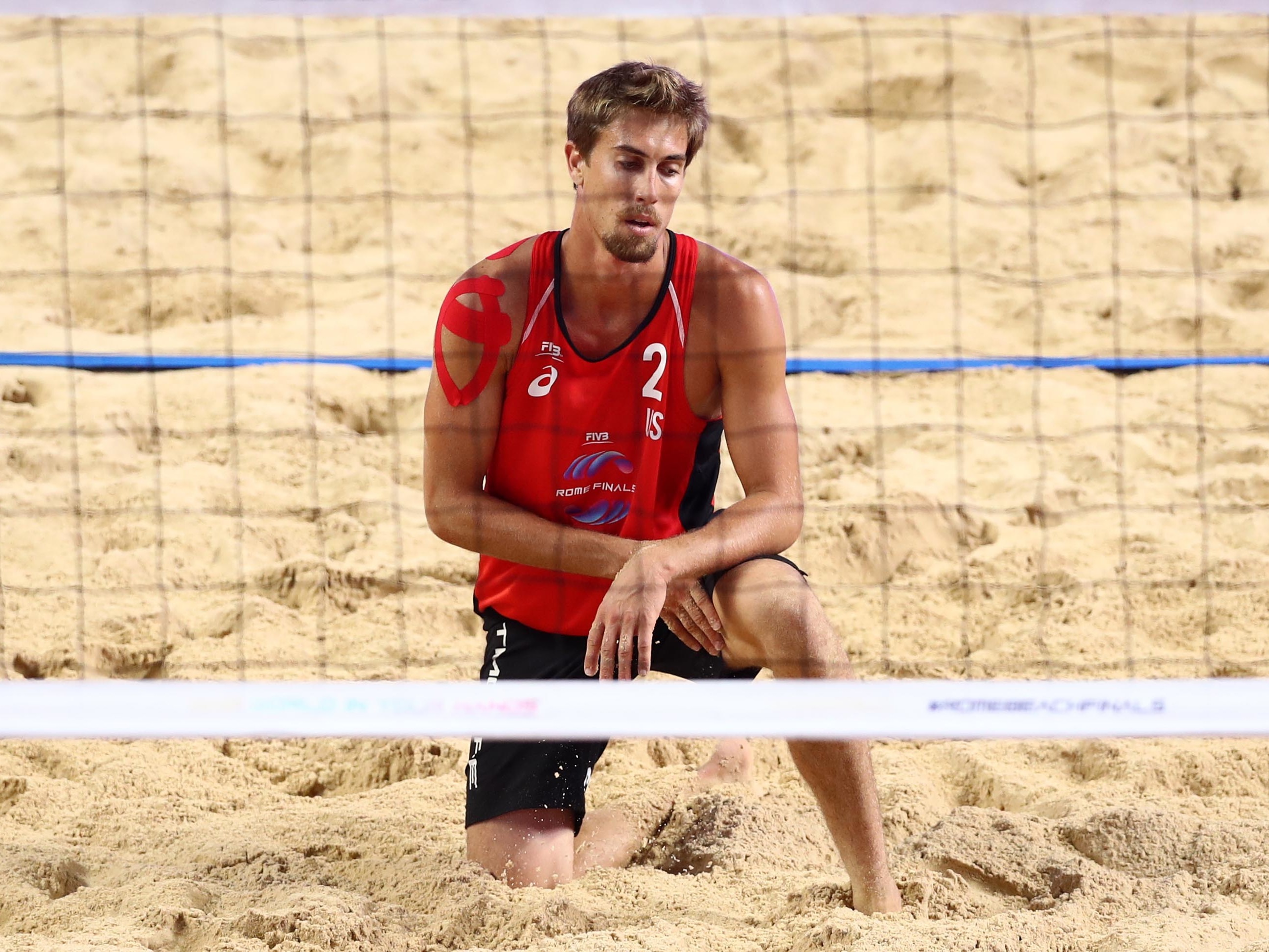 caption: Taylor Crabb, shown here during a 2019 beach volleyball match, tested positive upon arrival to Tokyo and was not able to compete at the Olympic Games.