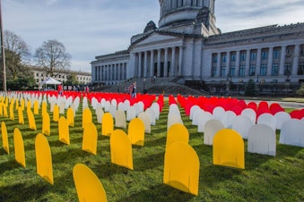 caption: A display in Olympia honors deaths by suicide in Washington. The red markers are suicides by gun.