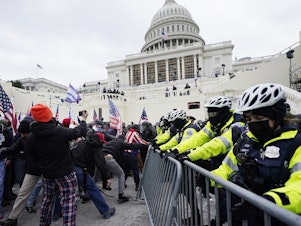 caption: Trump supporters try to break through a police barrier at the Capitol in Washington, D.C., on Wednesday. As Congress prepares to affirm President-elect Joe Biden's victory, thousands of people have gathered to show their support for President Trump.