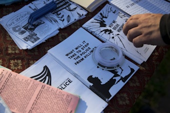 caption: A protester picks up a pamphlet titled, 'Why we break windows,' during a gathering organized by the Seattle Alliance Against Racism and Political Oppression following the reading of the guilty verdict in the trial of Derek Chauvin for the murder of George Floyd, on Tuesday, April 20, 2021, in Seattle.