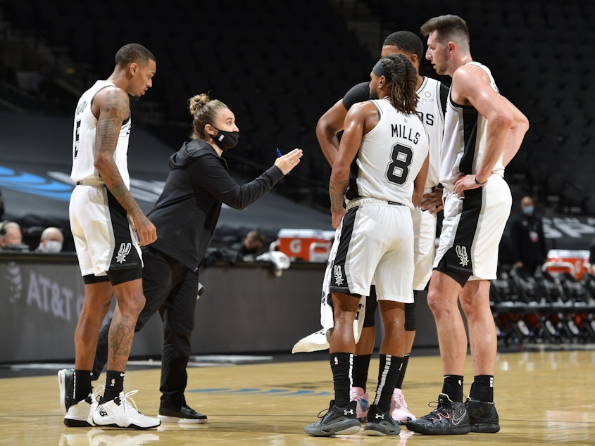 caption: San Antonio Spurs assistant coach Becky Hammon made NBA history Wednesday, becoming the first woman to lead a team in the regular season. She's seen here talking to her players as they faced the Los Angeles Lakers at the AT&T Center in San Antonio.