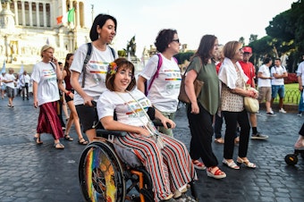 caption: People take part in a disability pride parade on July 14, 2019, in central Rome.