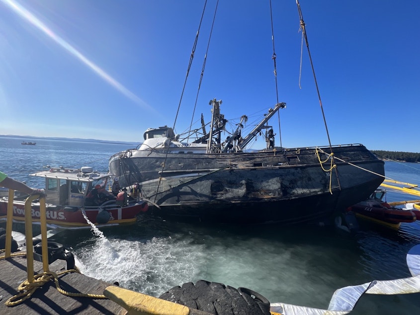 caption: A salvage team lifts the Aleutian Isle onto a barge on Sept. 21.