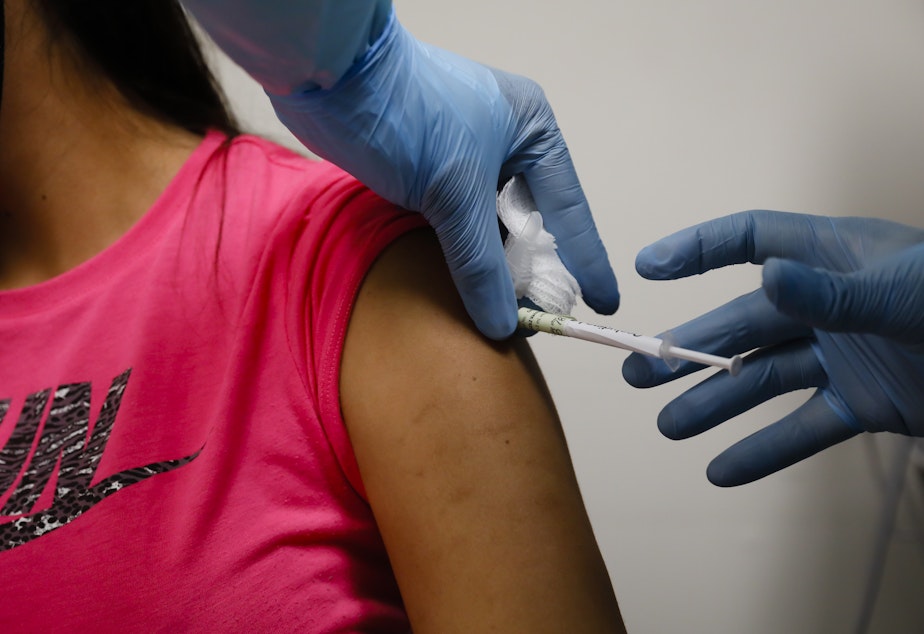 caption: A volunteer received an injection as part of a clinical trial for a COVID-19 vaccine at Research Centers of America in Hollywood, Fla. Studies of vaccines backed by Operation Warp Speed have enrolled tens of thousands of people in a matter of months.