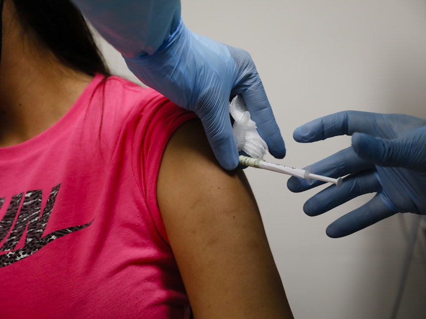caption: A volunteer received an injection as part of a clinical trial for a COVID-19 vaccine at Research Centers of America in Hollywood, Fla. Studies of vaccines backed by Operation Warp Speed have enrolled tens of thousands of people in a matter of months.