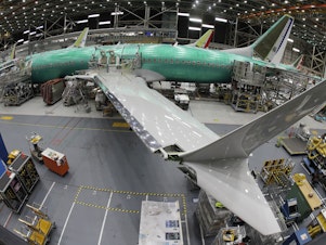 caption: A 737 Max 8 undergoes final assembly inside Boeing's factory in Renton, Wash., on March 27, 2019. Kansas-based Spirit AeroSystems makes the fuselages and ships them to Washington. A series of production issues at Spirit have led to problems.