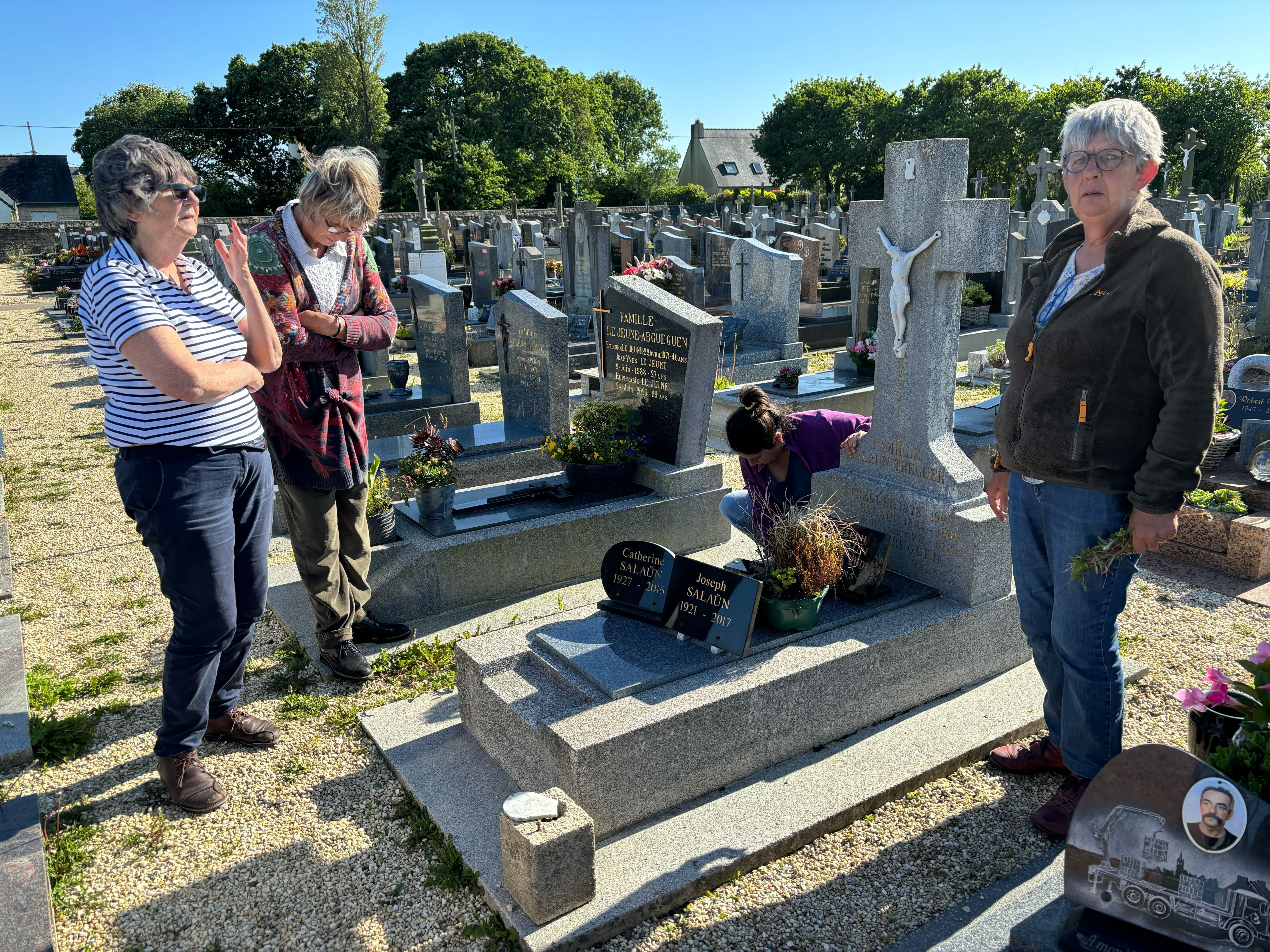 caption: From left: Michelle Salaün, Jeannine Plassard and Marie-Annick Gouez, the daughters of Catherine Tournellec Salaün, stand at their mother's grave in Plabennec, in France's Brittany region, in June.