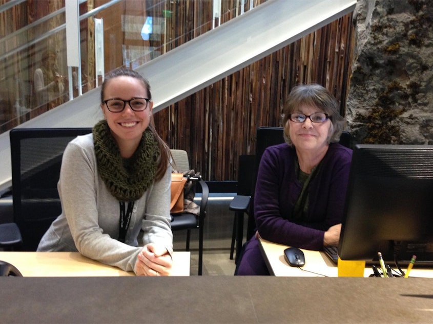 caption: Emily Holt (left) and Kathleen Cromp staff the Welcome Desk at Meridian Center for Health. The clinic provides medical, dental, mental health and maternal support services under one roof.