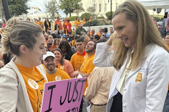 caption: Hannah Miles of Birmingham speaks with Dr Dr. Mamie McLean outside the Alabama Statehouse in Montgomery, Ala. on Feb. 28, 2024. They were among patients and doctors urging Alabama lawmakers to take action to get IVF services in the state. Fertility clinics paused some services in the wake of a state court ruling related to whether embryos are children under a state law.