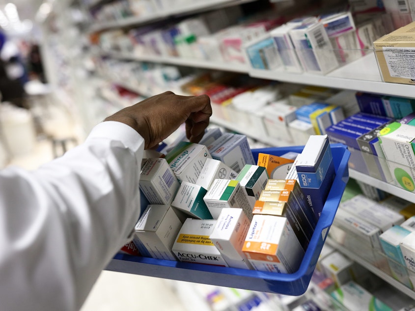 caption: A pharmacist collects packets of boxed medication from the shelves of a pharmacy in London, U.K. A proposal announced by House Speaker Nancy Pelosi Thursday would allow the government to directly negotiate the price of 250 U.S. drugs, using what the drugs cost in Australia, Canada, France, Germany, Japan, and the United Kingdom as a baseline.