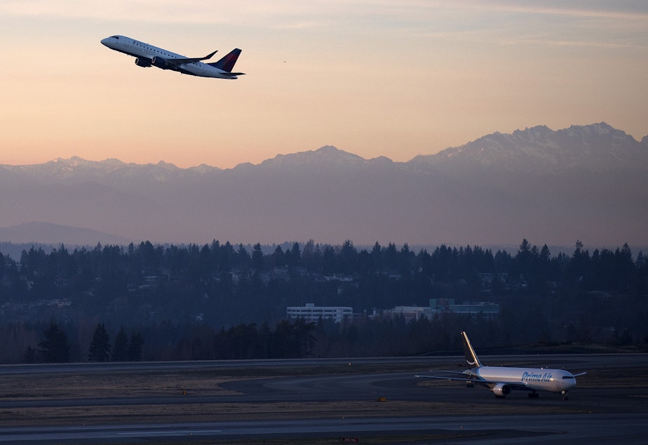 caption: A plane takes off on Monday, December 11, 2017, at Seattle-Tacoma International Airport. 