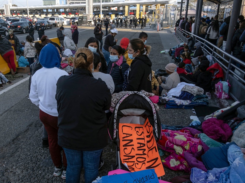caption: Migrants and asylum seekers are seen after spending the night in one of the car lanes off the San Ysidro Crossing Port on the Mexican side of the U.S.-Mexico border in Tijuana on April 24, 2021. A group of migrants asked U.S. migration authorities to allow them to start their migration process and decided to stay at the crossing port to pressure for a solution to their situation.