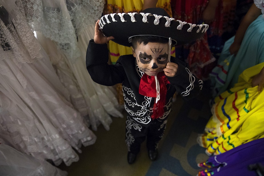 caption: Armani Galvez, 3, stands with other Folklore Mexicano Tonantzin members before performing on Friday, November 2, 2018, during the 14th annual Día de los Muertos celebration at El Centro de la Raza in Seattle. 