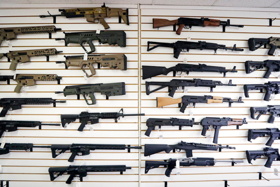 caption: In this Oct. 2, 2018, semi-automatic rifles fill a wall at a gun shop in Lynnwood, Wash. 