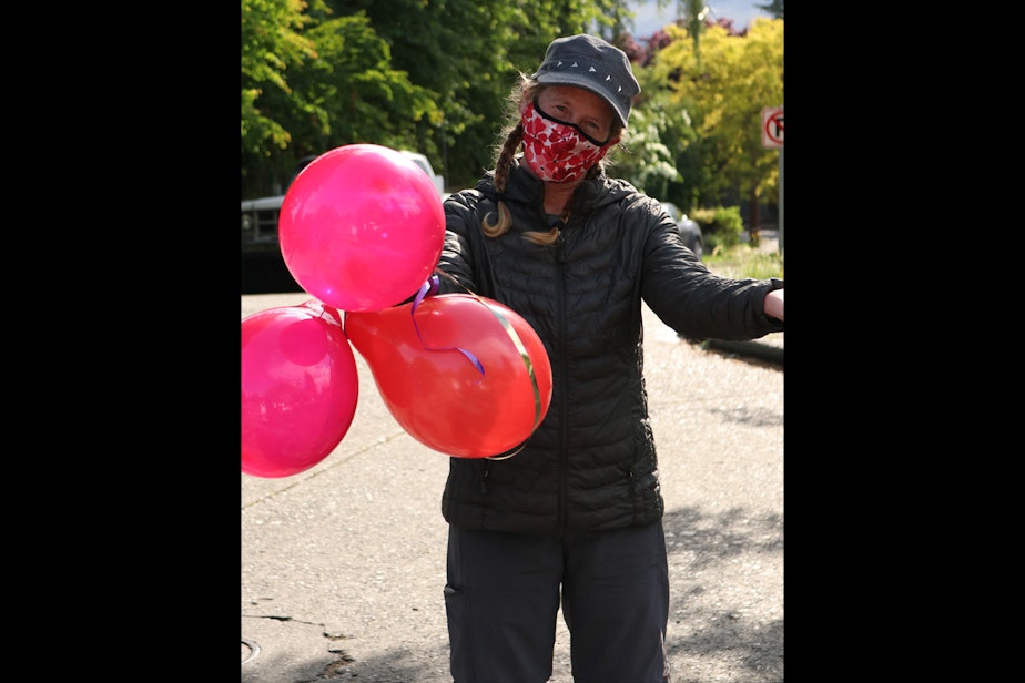 caption: My mom holds balloons at a block party graduation. Graduation parties have taken on a new flavor in the pandemic. Most are outside, and more intimate.