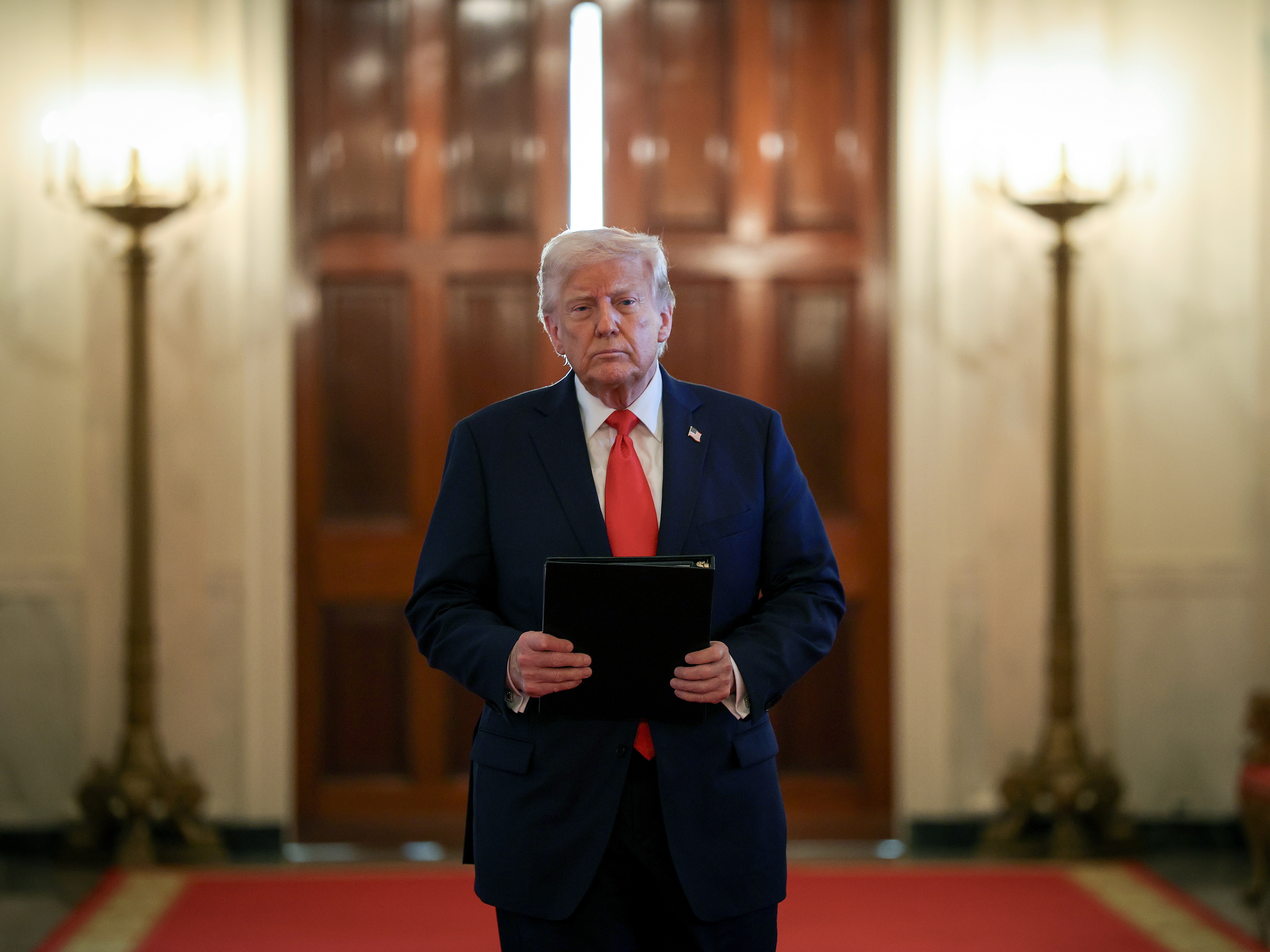 caption: President Trump arrives for a presentation ceremony for the Commander-in-Chief Trophy to the U.S. Naval Academy in the East Room of the White House on Tuesday.