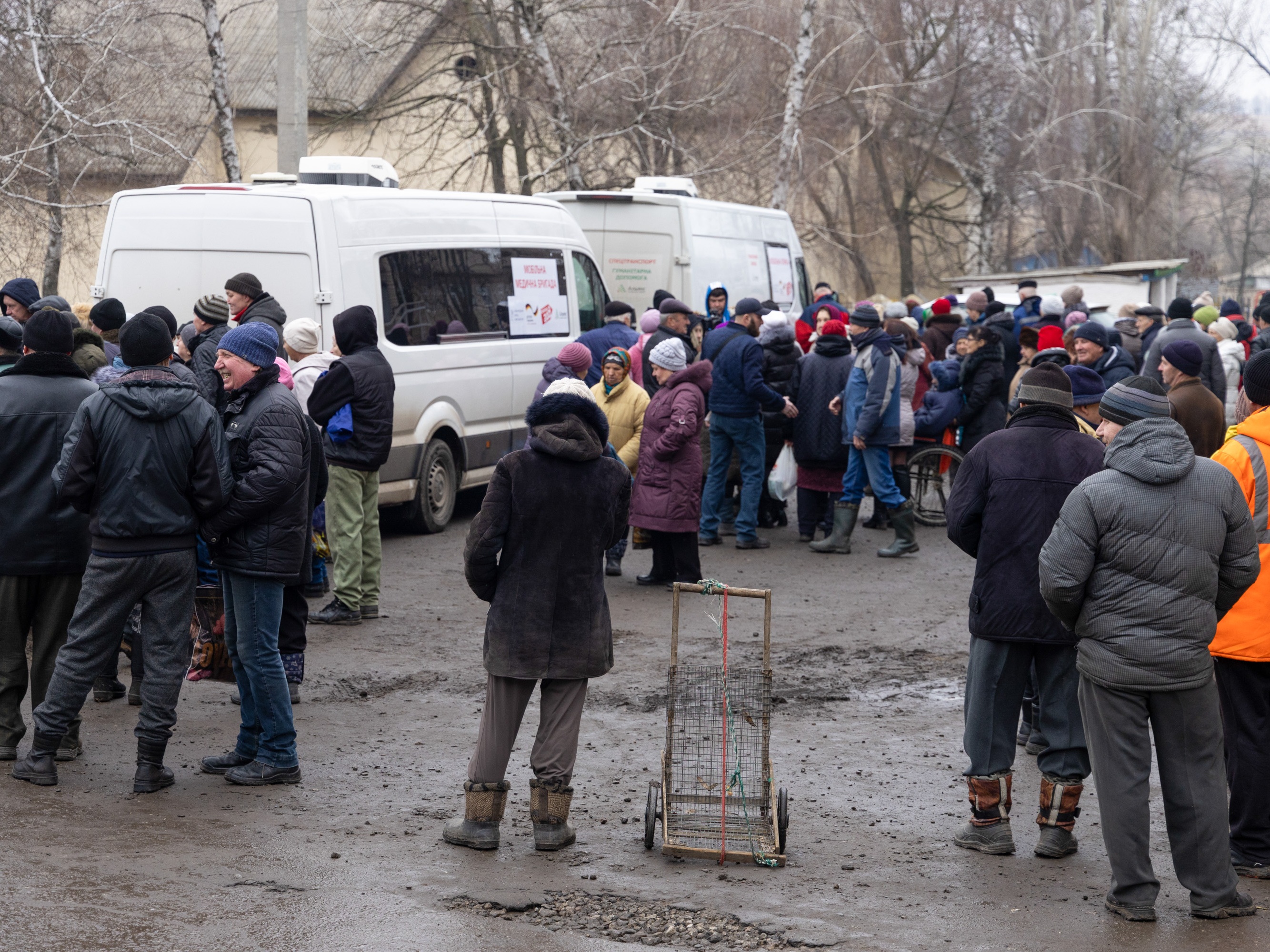 caption: A mobile lab visits a village in the war-torn Kharkiv region. Villagers line up for general checkups. HIV testing and treatment is a big part of the agenda.<br>