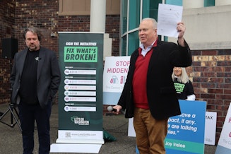 caption: Two key figures behind the initiative effort, financial backer Brian Heywood (left) and Washington State Republican Party chair Rep. Jim Walsh (R-Aberdeen), helped drop off petitions at the Secretary of State's office in Tumwater last fall in order to qualify the initiatives for ballot consideration in 2024. 