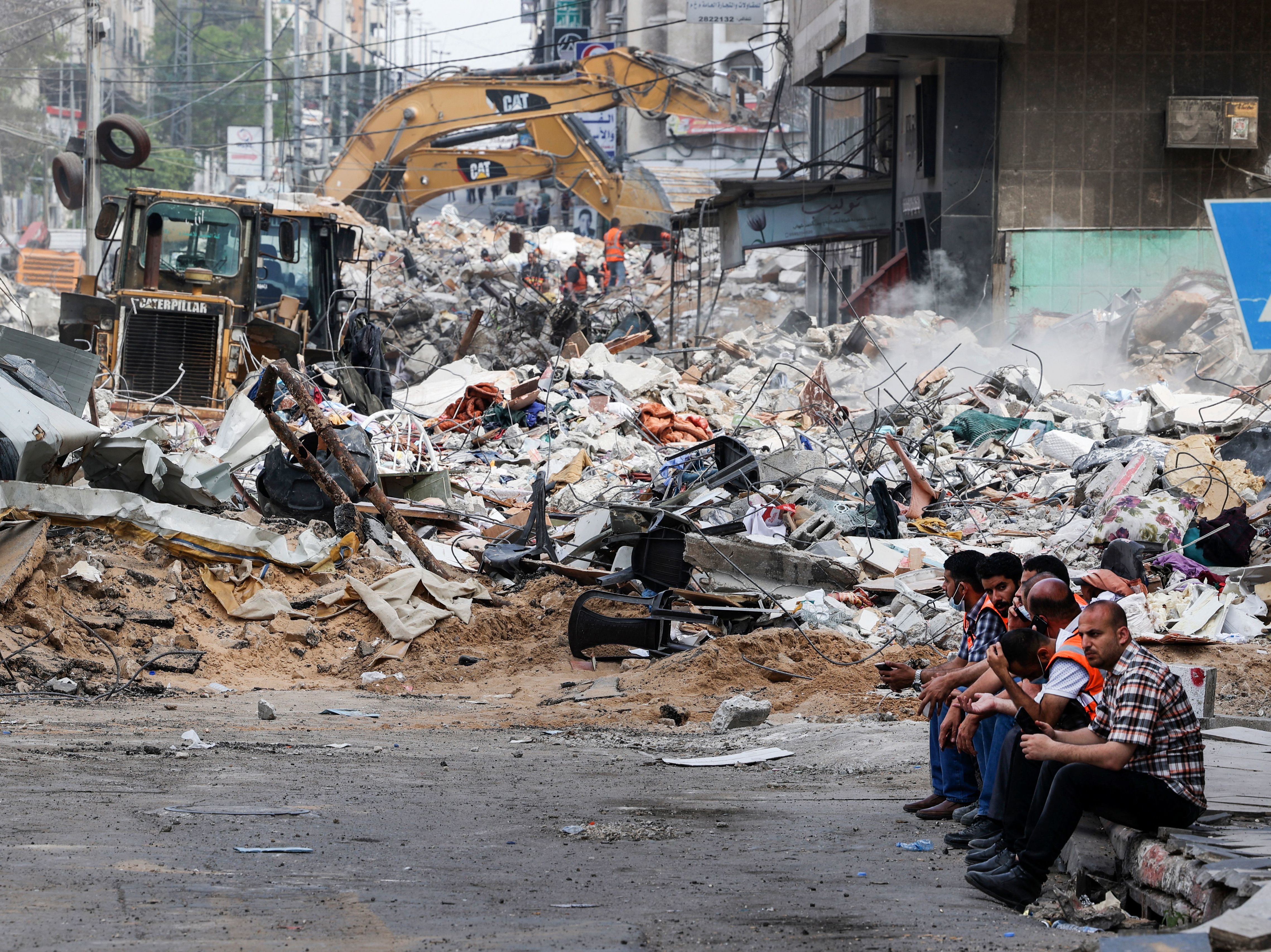 caption: An excavator clears the rubble of a destroyed building in Gaza City on Sunday, following Israeli airstrikes.
