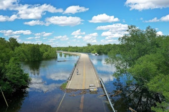 caption: Floodwater from the Mississippi River cuts off the roadway from Missouri into Illinois at the states' border on May 30, 2019 in Saint Mary, Missouri.