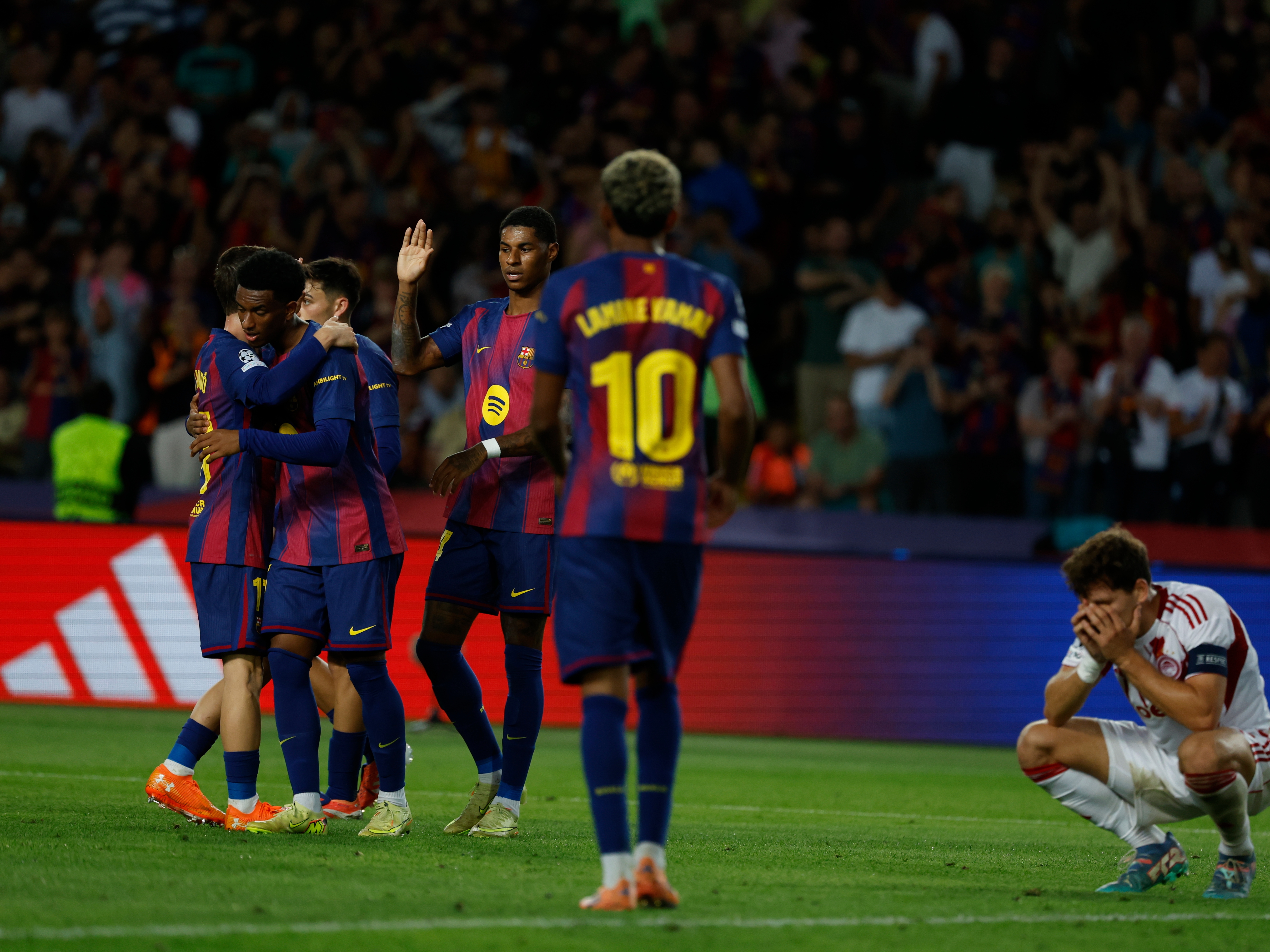 caption: Barcelona's players celebrate the sixth goal of their team during the Champions League opening phase soccer match between Barcelona and Olympiacos in Barcelona, Spain, on Tuesday.