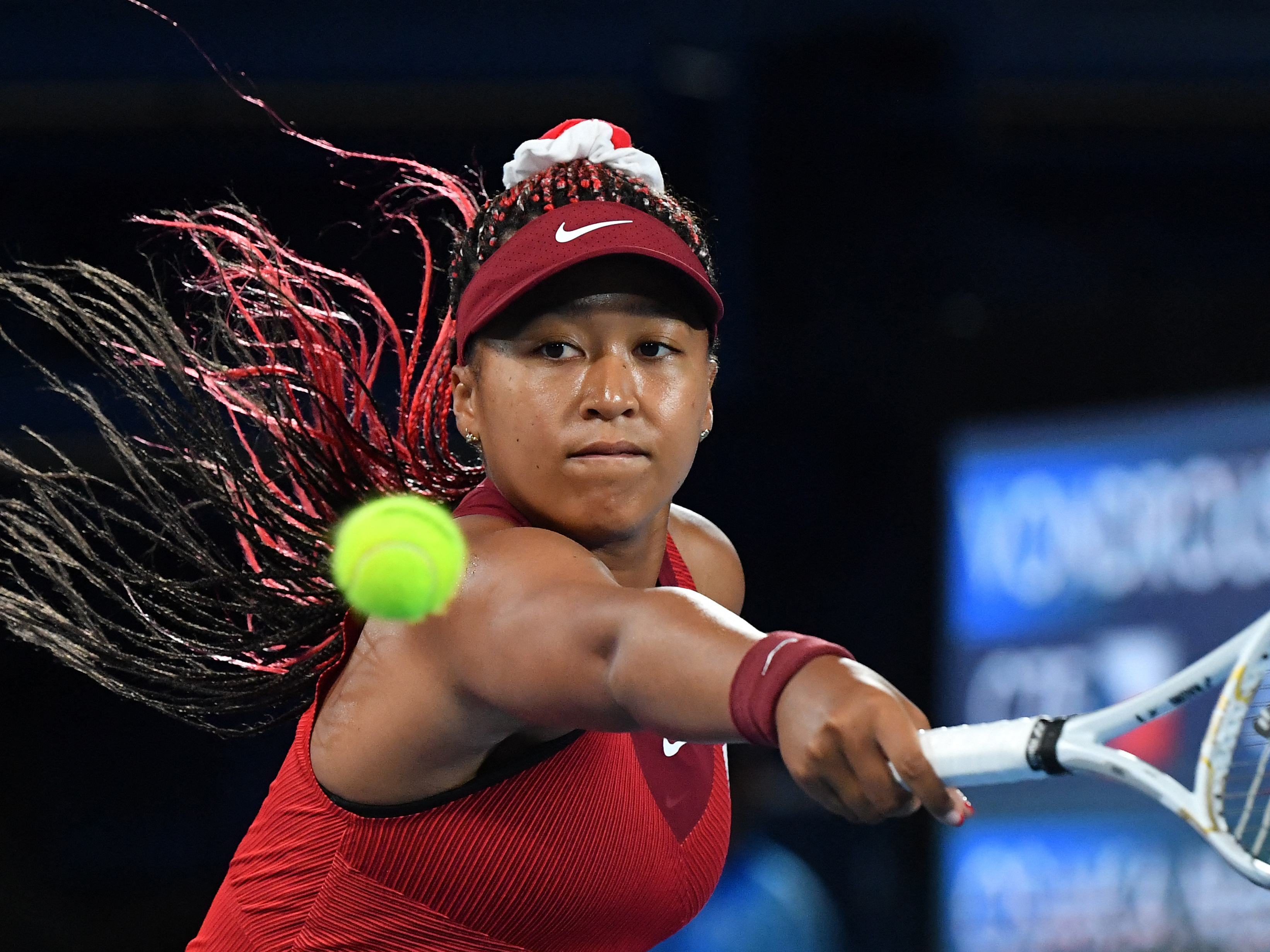 caption: Japan's Naomi Osaka returns the ball to the Czech Republic's Marketa Vondrousova during their third round tennis match at the Tokyo Games on Tuesday.