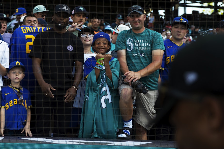 caption: Zayvion Jones, 9, center, reacts while getting his ball signed by a player on Friday, July 7, 2023, before the first ever HBCU Swingman Classic at T-Mobile Park in Seattle. 
