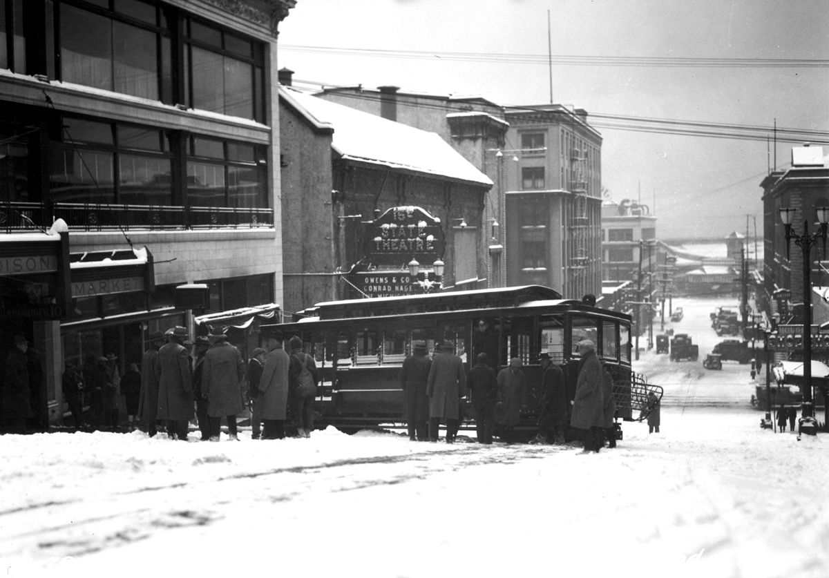 caption: In the grand tradition of Seattle's public transportation going ass over tea kettle: Madison Street Cable Car derailed in snow at 1st and 2nd avenues, Jan. 1929.