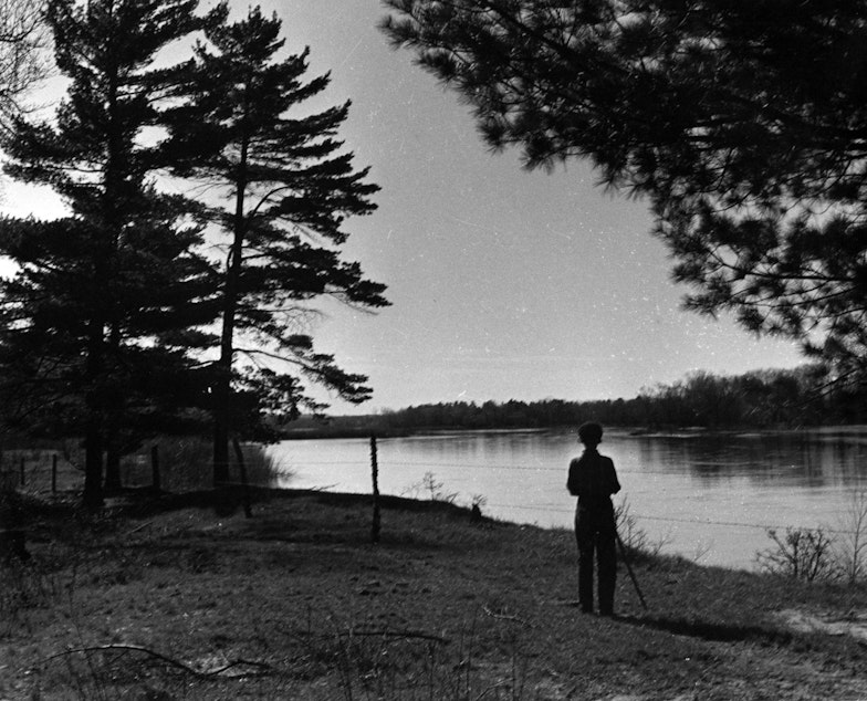 caption: Estella Leopold looks across the Wisconsin River from the family farm in 1938.