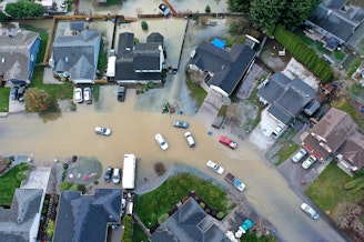 caption: Flooding from the White River is shown surrounding homes near Butte Avenue on Wednesday, December 17, 2025, in Pacific.