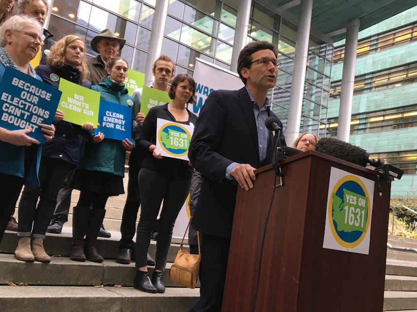 caption: Washington Attorney General Bob Ferguson speaks at a press event for the Yes on 1631 campaign.