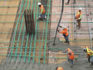 caption: SLIDESHOW: Workers pour concrete for a floor of an office tower in Renton. Pouring concrete carries a lot of risk for workers. 