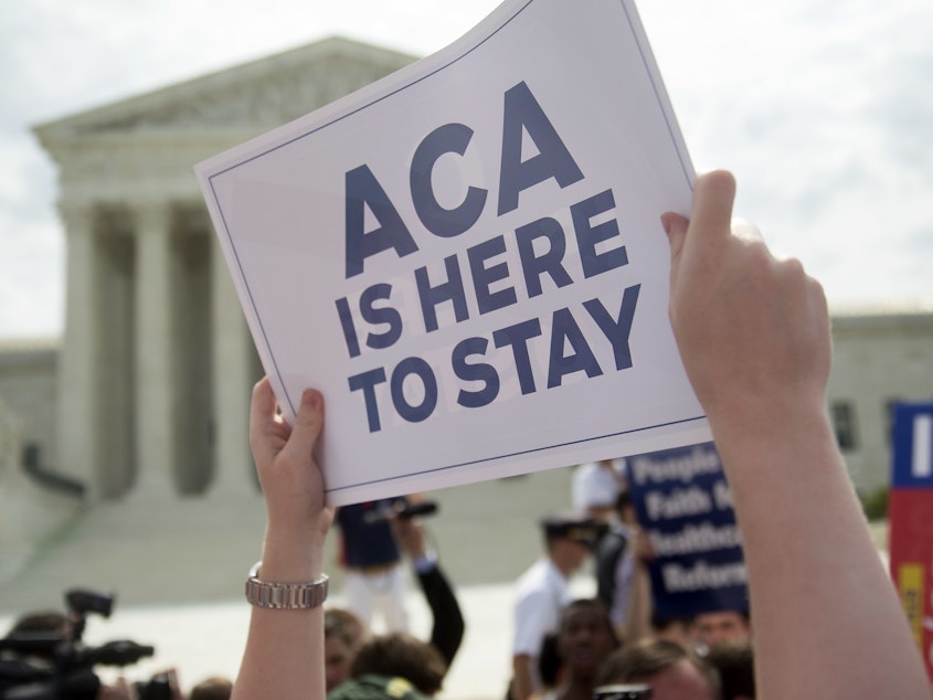 caption: A demonstrator celebrated outside the U.S. Supreme Court in 2015 after the court voted to uphold key tax subsidies that are part of the Affordable Care Act. But federal taxes and other measures designed to pay for the health care the ACA provides have not fared as well.
