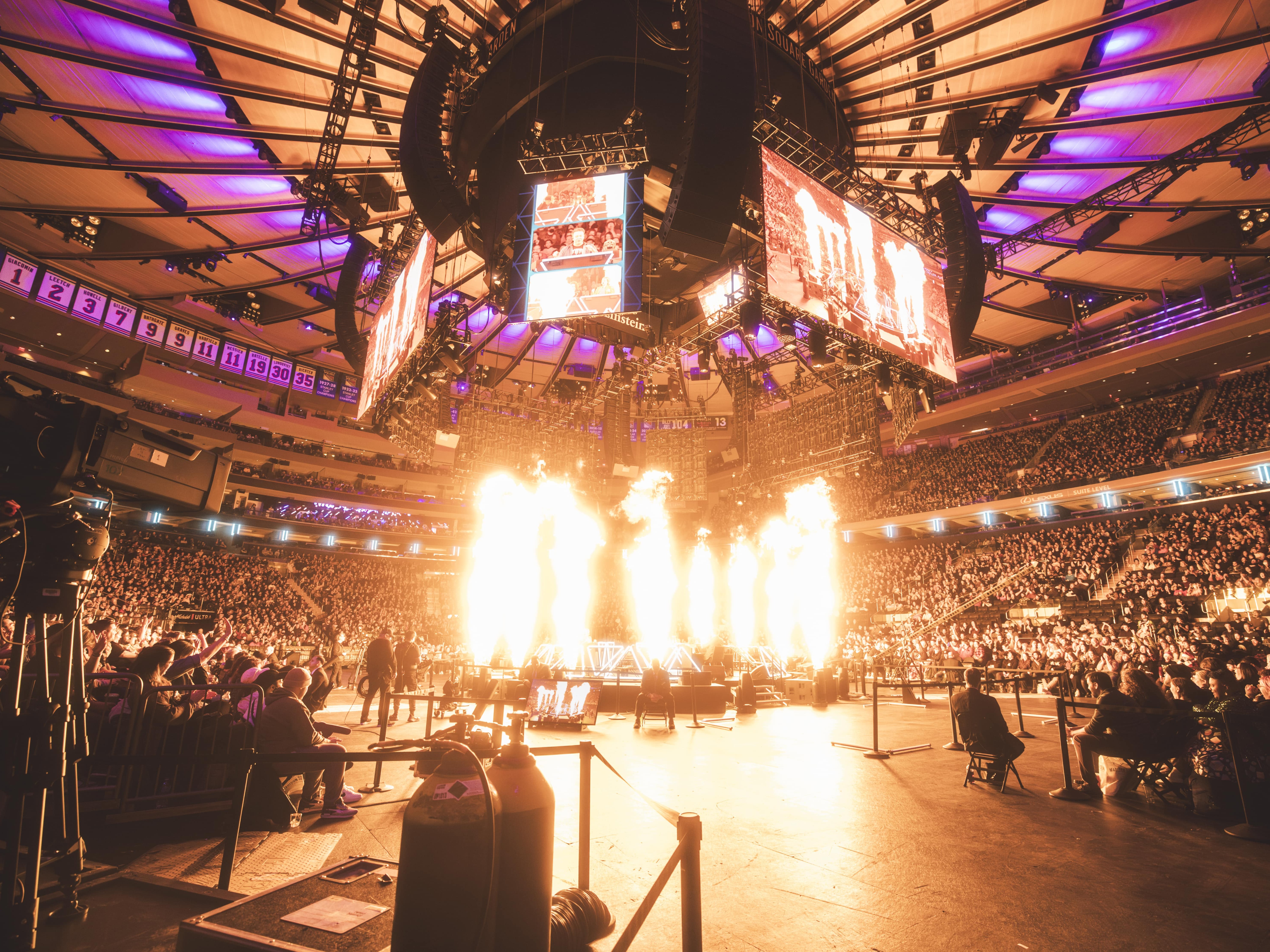 caption: Flames shoot up during <em>Dimension 20</em>'s sold-out Madison Square Garden show in January of 2025. <br>