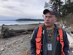 caption: Todd Mitchell is the environmental director for the Swinomish Tribe. Behind him is the south beach of the Kukutali Preserve. 