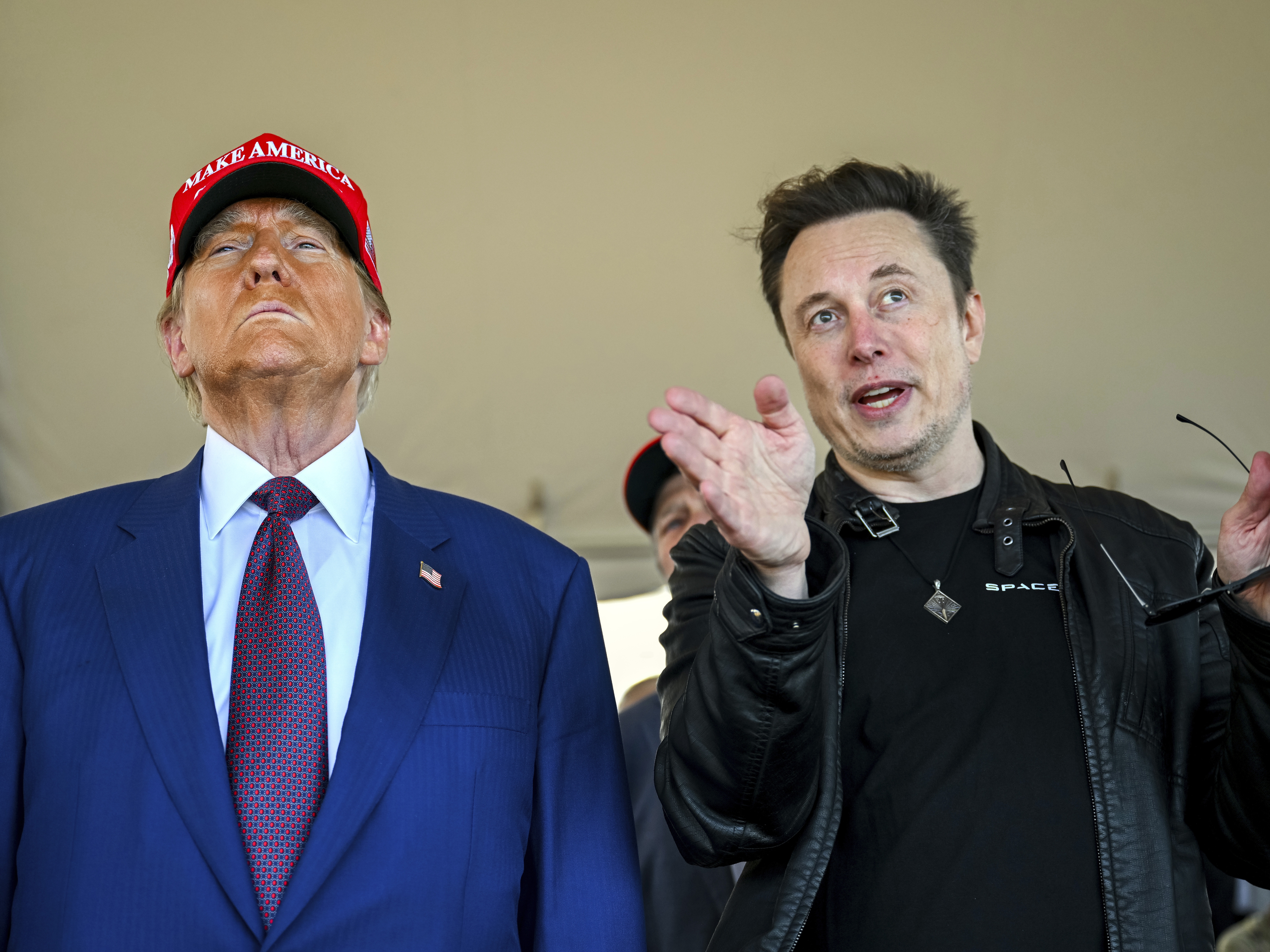 caption: President-elect Donald Trump listens to Elon Musk as he arrives to watch SpaceX's mega rocket Starship lift off for a test flight from Starbase in Boca Chica, Texas, on Nov. 19.