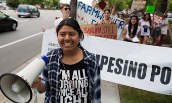 caption: Alicia Santos, 17, leads marchers in a protest targeting Sakuma Brothers Farm.